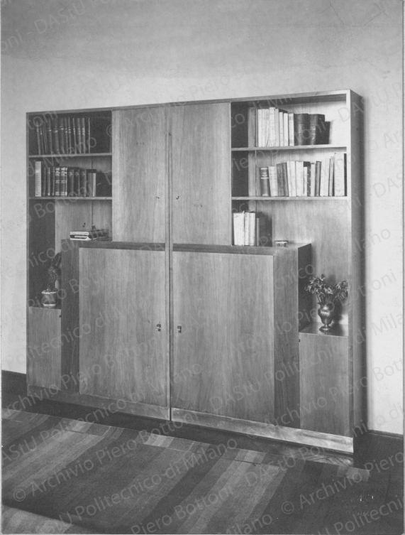 Veduta dell'armadio libreria. Timbro a secco "Paoletti fotografo Milano". Positivo, bianco e nero,191x144 mm,  album giallo n.8, pag.61.