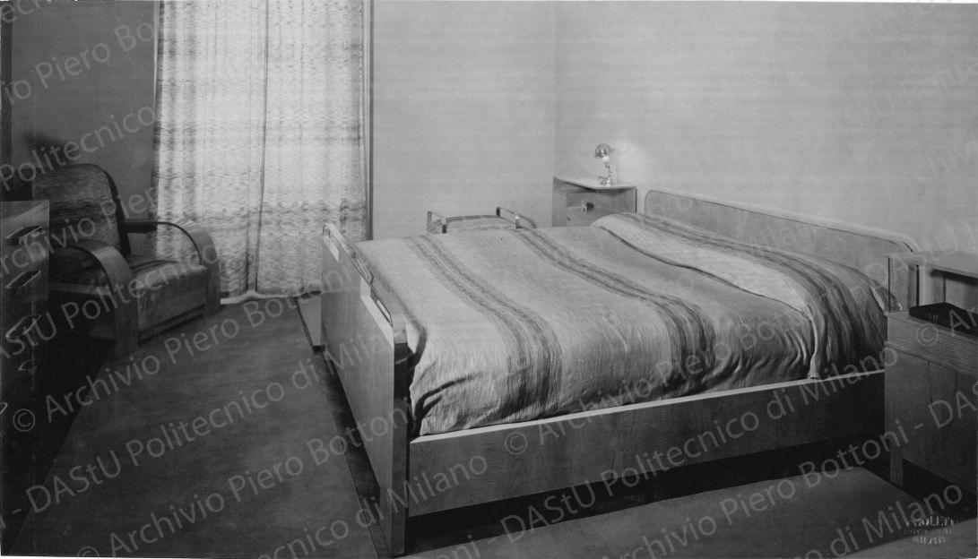 Veduta della camera da letto. Didascalia manoscritta: "...i legni chiari danno alla camera da letto un senso di freschezza e di pulizia". Timbro a secco "Paoletti fotografo Milano". Positivo, bianco e nero, 158x277 mm,  album giallo n.8, pag.73.