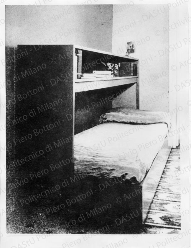 Veduta del "Tavolino per camera da letto", positivo, bianco e nero, mm 165x190.  Timbri ad inchiostro sul verso: "Piero Bottoni" e "Da restituire". Annotazione manoscritta sul verso: "Un tavolino per camera da letto che si presta assai bene anche per il servizio di prima colazione: nella parte bassa ha piccole ruote invisibili".