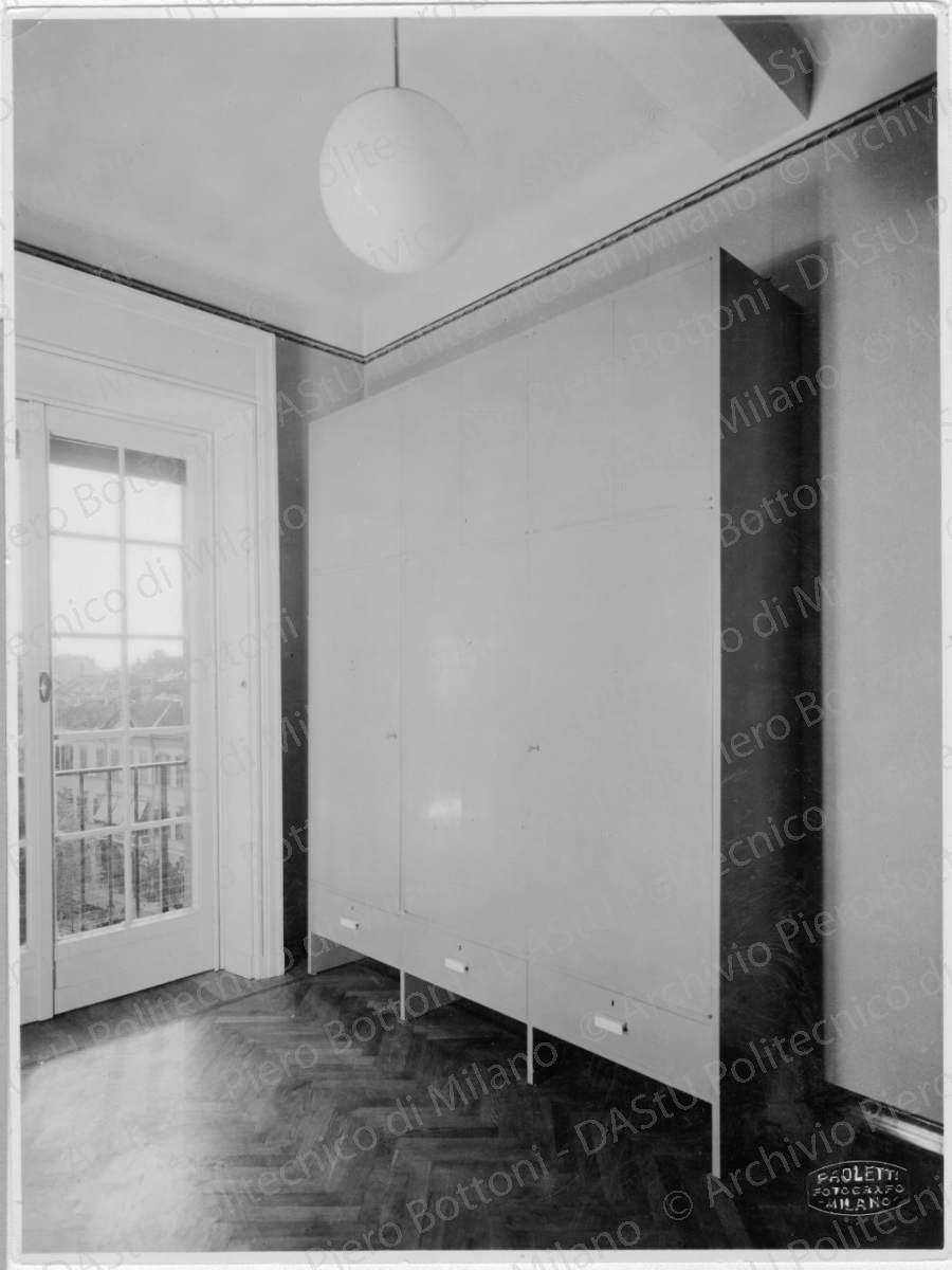 Idem, in formato differente, positivo, bianco e nero, mm 225x169. Timbri ad inchiostro sul verso: "Piero Bottoni" e "Da restituire". Annotazione dattiloscritta sul verso: "Mobile grande di guardaroba in casa Ing. B. A. Milano. Sportelli, ante e cassetti con maniglie in galattite. Tinteggiatura grigio-azzurra alla nitrocellulosa."
