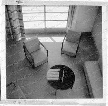 Veduta del soggiorno dal soppalco, positivo, bianco e nero, mm 60x60. Fotografia in album.