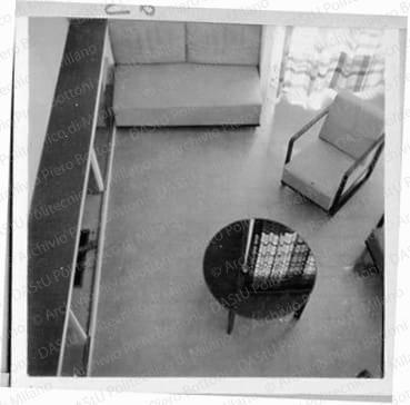 Veduta del soggiorno dal soppalco, positivo, bianco e nero, mm 60x60. Fotografia in album.