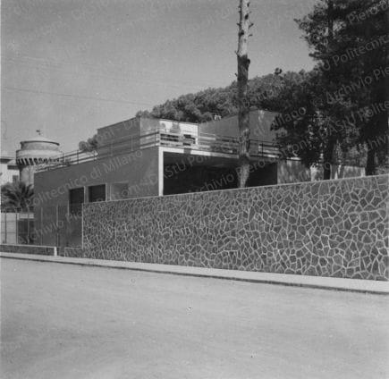 Veduta del prospetto sud-ovest. Didascalia dattiloscritta: "1934 - Casa Dello Strologo a Livorno. Due temi sono proposti in questo edificio: il rovesciamento della tradizionale facciata su strada, verso l'interno dell'area e verso il giardino; l'uso di materiali tradizionali (blocchi di pietra tradizionalmente impiegati a Livorno per l'interno "delle murature" con finiture (il giunto) di una tecnica e di una estetica nuove". Positivo, bianco e nero, 247x235 mm, album giallo n.19, pag.17.