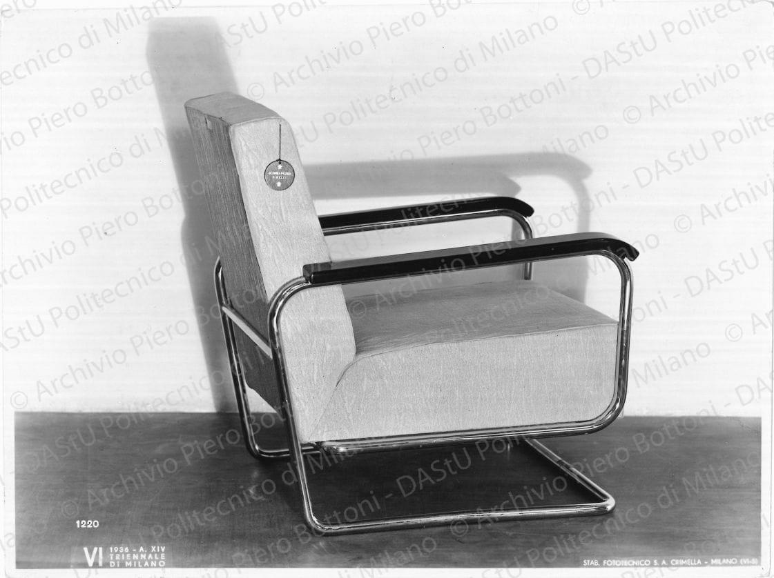 Veduta della poltroncina in tubo d'acciaio. Annotazione tipografica sul recto della fotografia: "VI Triennale di Milano 1936 - A. XIV. Stab. Fototecnico Crimella - Milano (VI-5). 1220". Positivo, bianco e nero, 175x237 mm, album giallo n.8, pag.116.