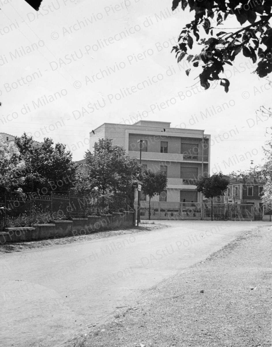 Vista del prospetto nord da via Usiglio, positivo, bianco e nero, mm 235x184.  Annotazioni manoscritte sul verso. Timbro ad inchiostro con annotazioni manoscritte sul verso: "Domus. Ricevuto marzo 1941. Autore Bottoni e Pucci. Pubblicato in scarti [segue testo barrato: n. aprile 1941]. Soggetto[segue testo barrato: scarti] una casa con sei appartamenti."
