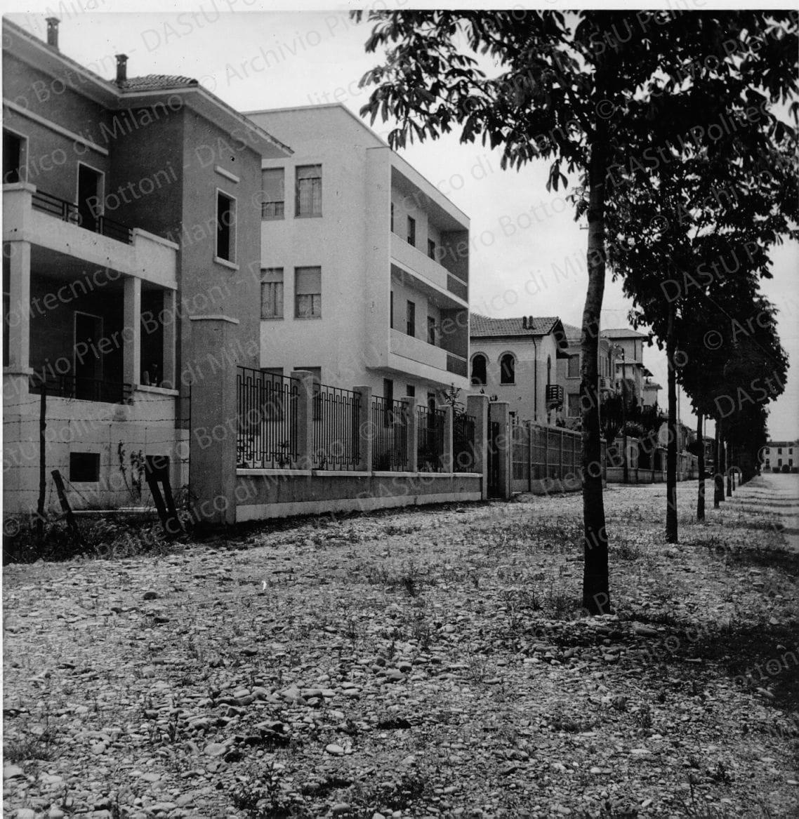 Idem, in formato differente, positivo, bianco e nero, mm 176x126. Annotazione dattiloscritta su velina incollata sul verso della fotografia: "...Veduta della casa dal Viale di circonvallazione. La costruzione improntata ad una chiara linearità costruttiva risalta in mezzo alla serie dei villini costruiti nei più svariati stili".